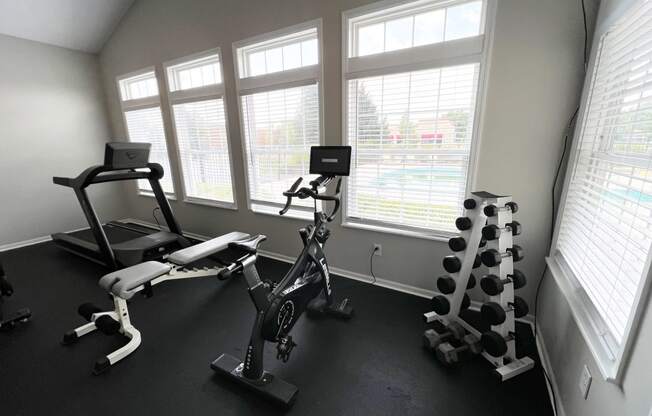 a gym with exercise equipment in a room with windows at Traditions at Slate Ridge, Reynoldsburg Ohio