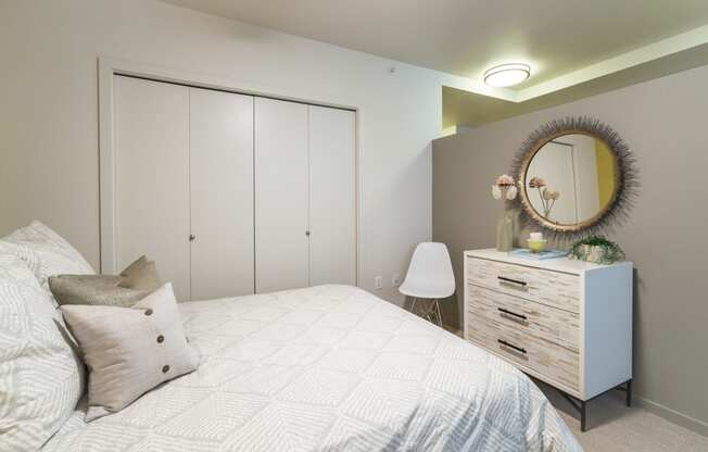 a bedroom with a bed and a dresser with a mirror