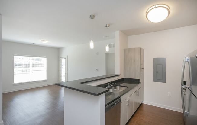 a kitchen with white walls and a black counter top