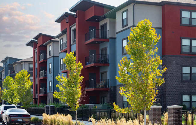 A row of modern apartment buildings with trees in front.