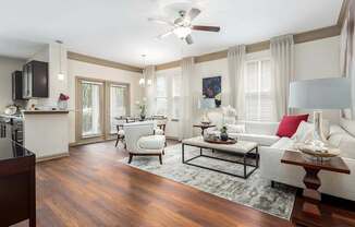 A living room with a white couch, a coffee table, and a ceiling fan.