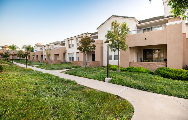 A row of houses with a sidewalk in front.