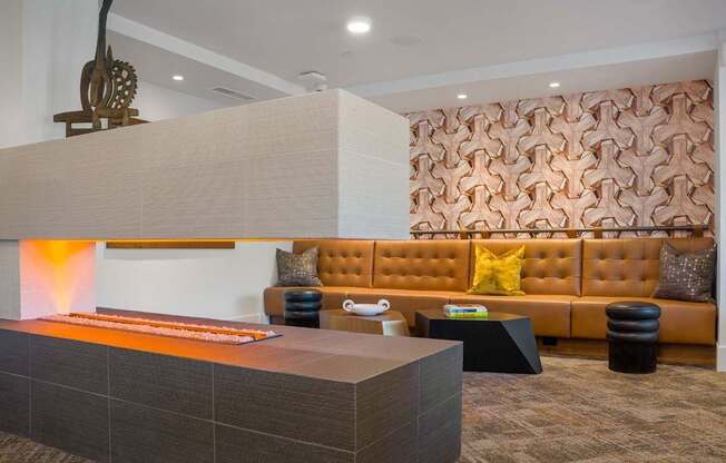 A modern living room with a brown sofa and a wooden sculpture on the wall.