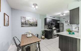 A kitchen area with a dining table and chairs.