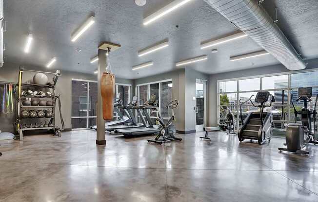 A gym with a variety of equipment including treadmills, weights, and exercise machines.