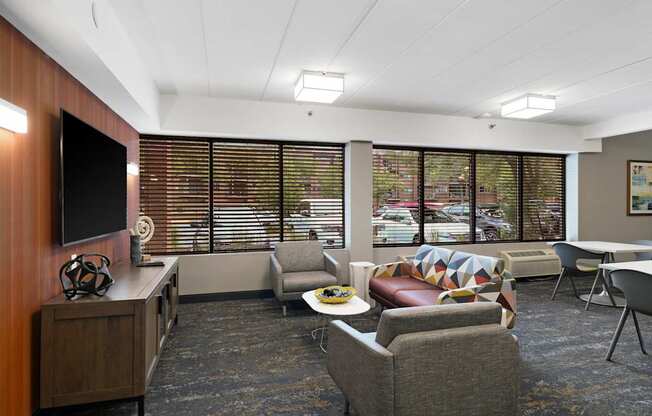 A modern waiting room with a flat screen TV and comfortable seating.