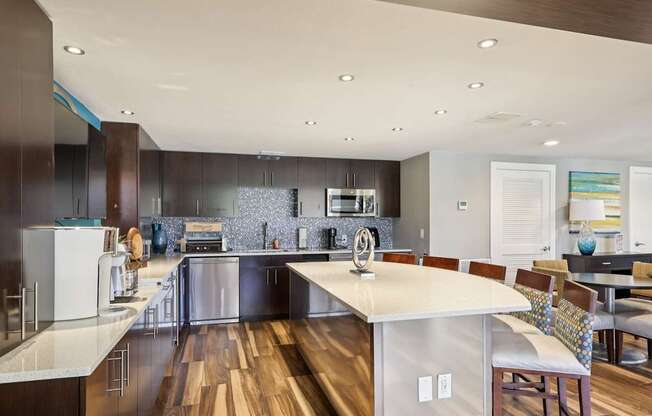 A modern kitchen with a center island and stainless steel appliances.