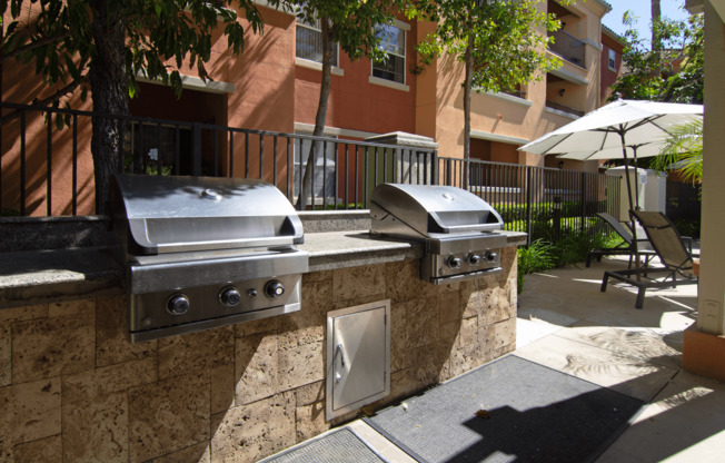 Two built-in grills on a stone wall outside a building.