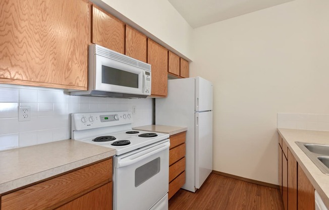 a kitchen with white appliances and wooden cabinets