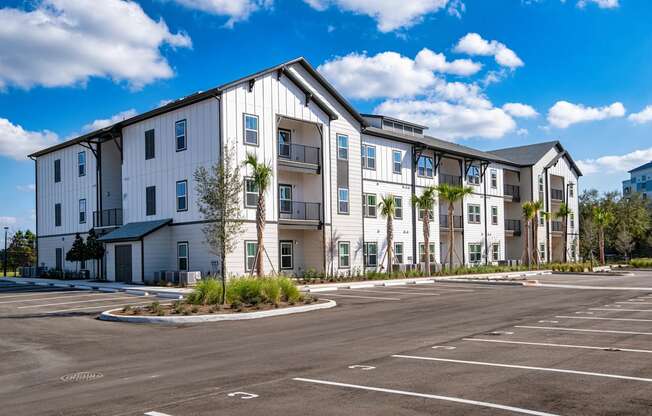 A large white building with a parking lot in front.