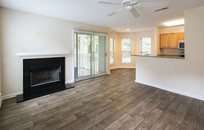 A living room with a fireplace and patio sliding glass doors.