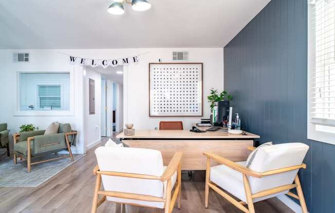 a living room with blue walls and a desk and chairs