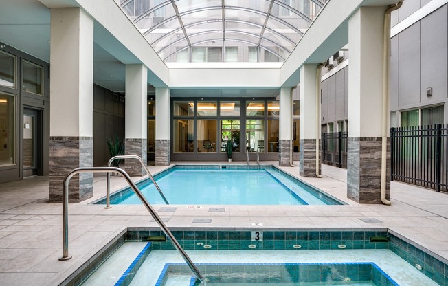 a swimming pool in the middle of a building with a glass ceiling