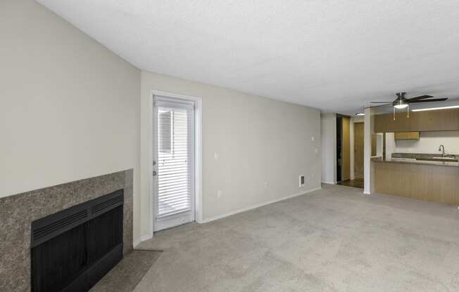 a living room with a fireplace and a kitchen in the background at Willows Court Apartment Homes, WA 98125