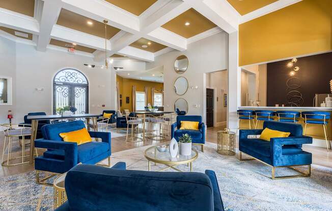A large room with blue chairs and a gold coffee table.