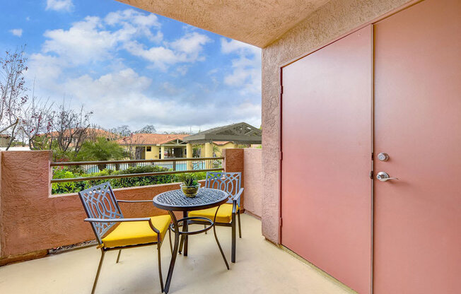 A patio with a table and chairs overlooking a mountain.