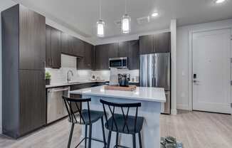 a kitchen with a large island with three stools