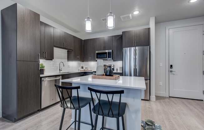 a kitchen with a large island with three stools