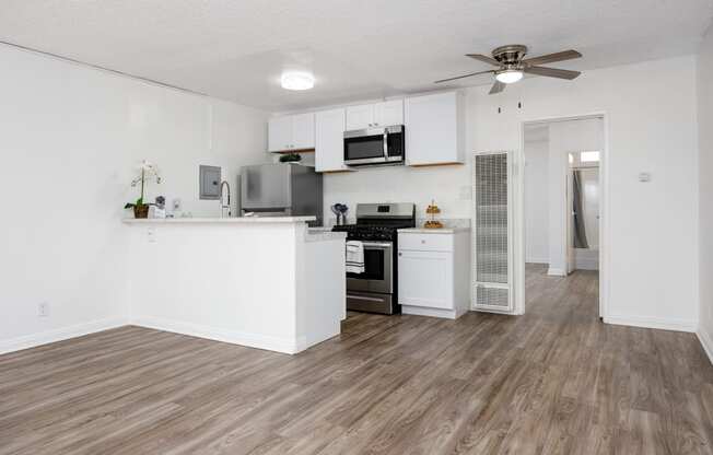 an open kitchen and living room with a ceiling fan