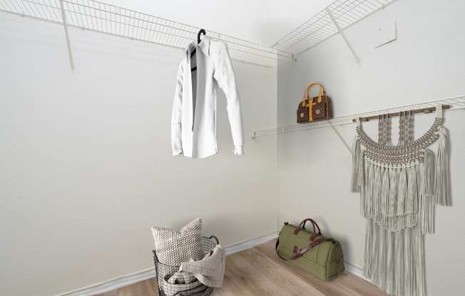 a walk in closet with a white jacket hanging on the wall