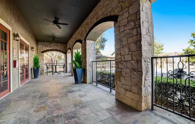 A patio with a stone floor and a black metal railing.