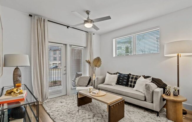 a living room with a couch and a ceiling fan