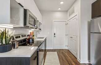 A modern kitchen with white cabinets and a stainless steel refrigerator.