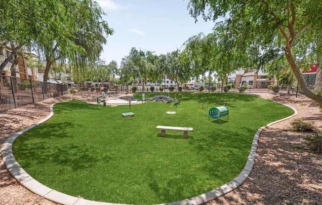 A park with a green lawn and a bench.