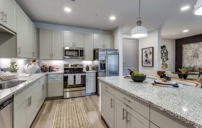 an open kitchen with white cabinets and granite counter tops