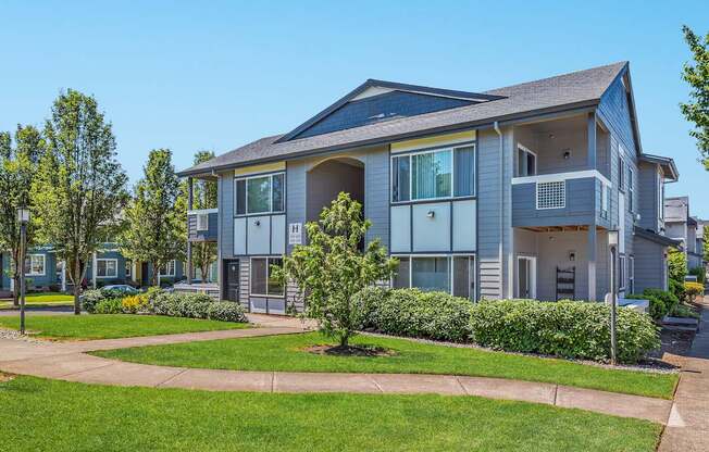 A large grey apartment building with a small tree in front at The Landing Apartments and Townhomes, Oregon, 97045