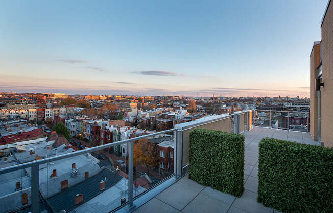A balcony overlooks a cityscape at sunset.