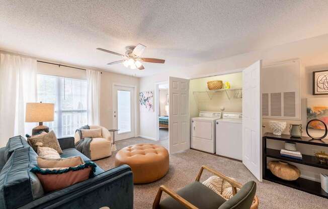 A living room with a blue couch and a brown chair.