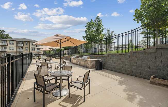A patio with a table and chairs and an umbrella.