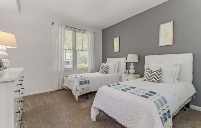 Two bedrooms with white beds and pillows.