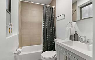 A bathroom with a white tub, toilet, and sink.