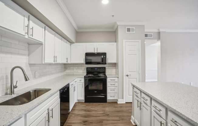 a white kitchen with white cabinets and a black stove and oven  at The Verandah, Austin, 78726