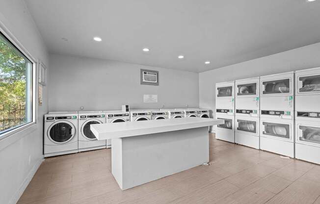 a laundry room with a counter and washes and dryers in it