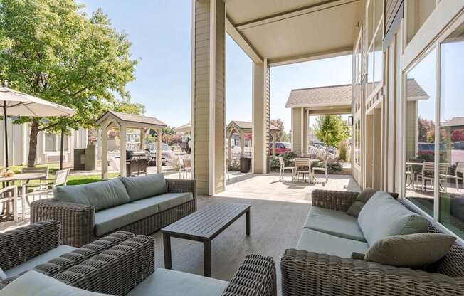 A patio with a table and chairs is covered by a roof.