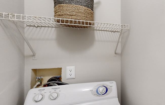 a white washer and dryer in a laundry room with a basket on top