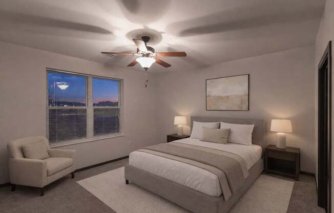 A calm bedroom here at The Park with soft neutral bedding, matching nightstands with lamps, a cozy accent chair, and plush carpet, creating a peaceful, spacious, and inviting retreat.