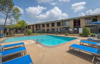 our apartments offer a swimming pool and a patio with blue benches