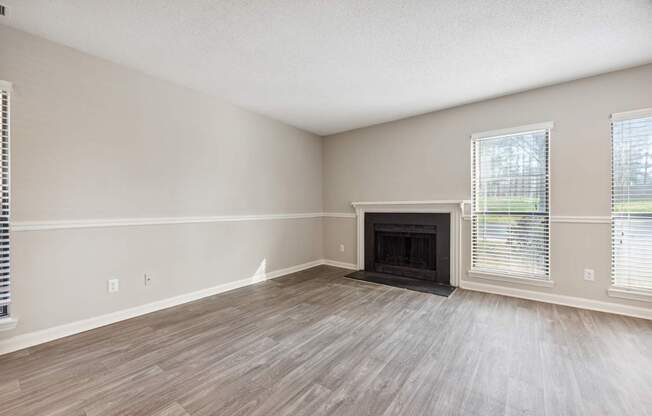 A room with a fireplace and wood flooring.