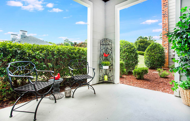 A patio with a table and chairs is surrounded by a brick wall.