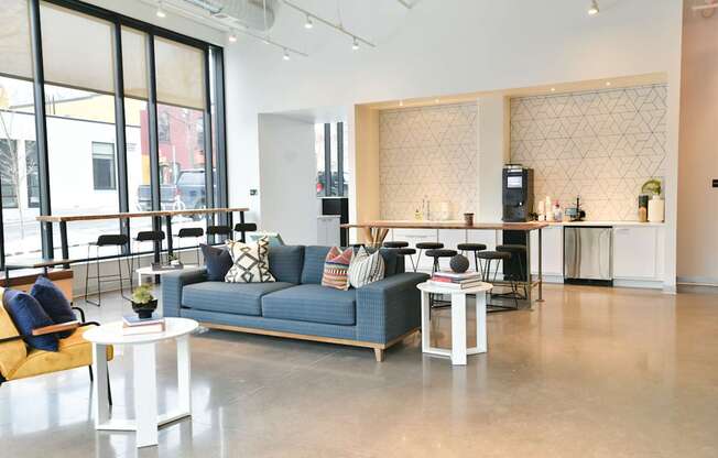 A living room with a blue couch and a white coffee table.