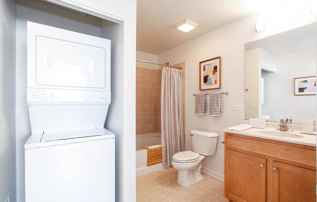 A white washing machine is in a small laundry room.