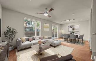 A living room with a grey couch, a coffee table, and a dining table with chairs.