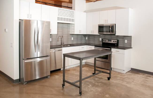 Kitchen with White Cabinetry, Stainless Steal Appliances and Movable Island at 700 Central Apartments, MN, 55414