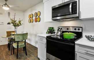 A kitchen with a black stove top oven and a black microwave above it.