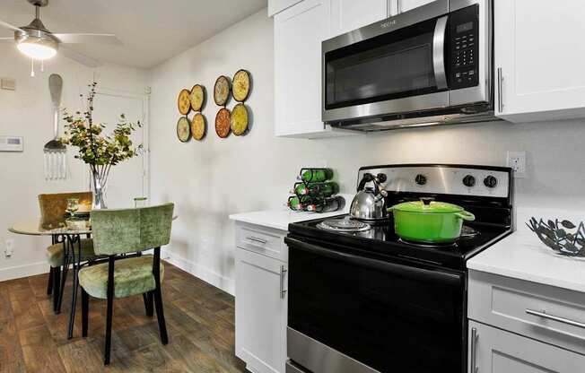 A kitchen with a black stove top oven and a black microwave above it.