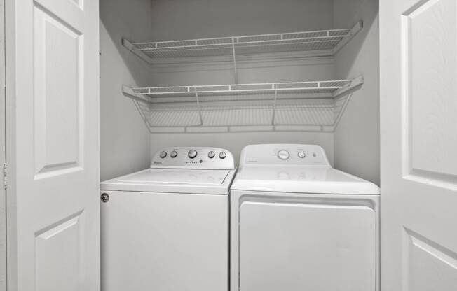 an empty laundry room with two washes and a dryer